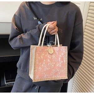 Detail of pink tote bag featuring white 3D butterfly embroidery and linen patchwork