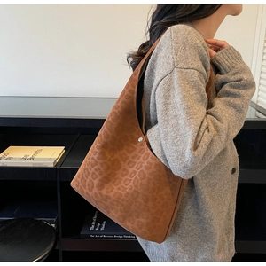 Side view of leopard print suede hobo bag on shoulder showing large capacity and shape