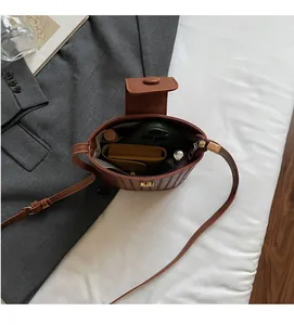 Internal view of brown woven bucket bag showing space for phone and wallet