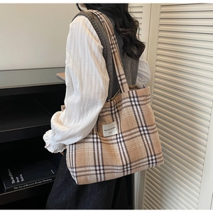 Detail showing high-quality plaid canvas tote bag worn on shoulder in a retro style