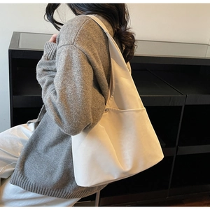 Detailed view of cream matte tote bag showing side shoulder carry on model profile