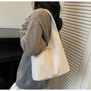 Detail of white leopard-textured oversized tote bag worn by model for daily commute
