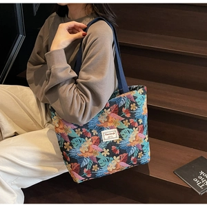 Detailed shot of large jacquard tote bag with tropical leaf pattern and woven straps