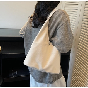Detail view of large capacity vintage matte hobo tote bag worn by a model in soft beige
