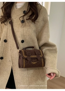 Retro leopard print handbag with gold studs worn over a classic beige coat
