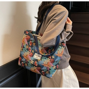 Detailed view of the colorful floral woven fabric and sturdy strap on the large tote bag
