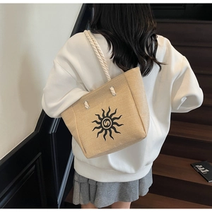 Detailed back view of a large linen bucket tote with sun pattern and rope handles
