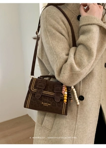 Detail of leopard print crossbody bag with gold studs and beaded strap charm
