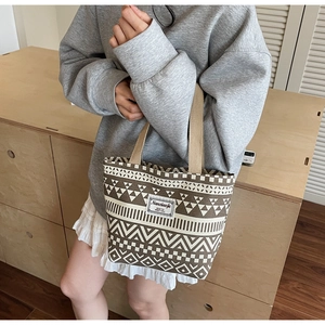 Close-up of geometric pattern and brand logo label on a canvas tote bag