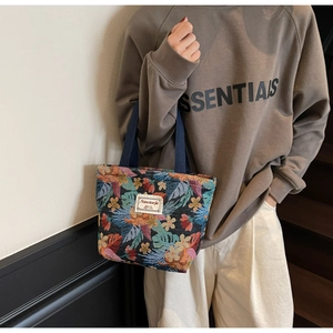 Close-up of floral jacquard fabric tote bag featuring colorful botanical embroidery patterns