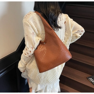 Brown woven hobo bag with adjustable buckle strap and crocodile pattern texture detail