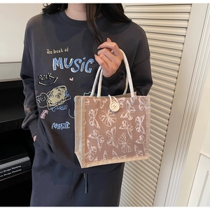 Close-up of linen tote bag featuring 3D white lace butterfly embroidery and rope handles