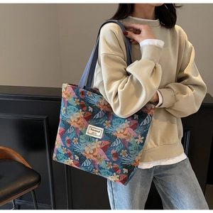 Close-up of tropical floral jacquard fabric and brand label on large tote bag