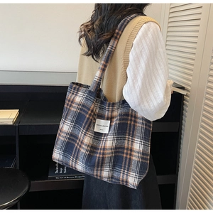 Detail of tartan canvas tote bag featuring navy, beige and orange plaid patterns