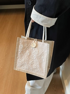 Linen tote bag with white floral embroidery and woven handles for women