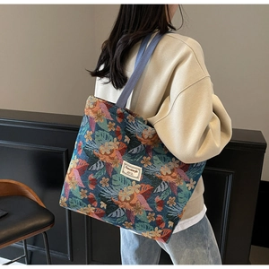 Detail of a large ethnic tote bag with tropical flower pattern shown on model shoulder