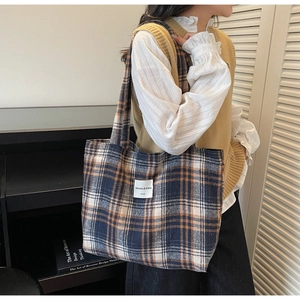 Close-up of navy and orange checkered tote bag featuring a white woven brand label tag