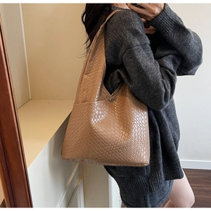 Close-up of the light brown woven texture and magnetic buckle on the large tote bag