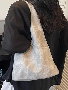 Grey large capacity tote bag with vintage matte texture shown on model shoulder