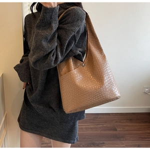 Macro shot of dark brown woven leather texture on a large hobo tote bag with magnetic clasp