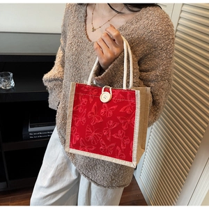 Detail of red butterfly tote bag with linen sides, rope handles and white button closure