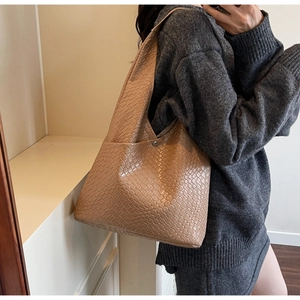 Detailed view of woven khaki tote bag with checkerboard pattern on PU leather strap