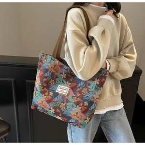 Detail view of large floral embroidery tote bag worn over the shoulder for casual style