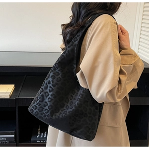 Close-up of the tactile leopard print texture and matte finish on the large hobo tote bag