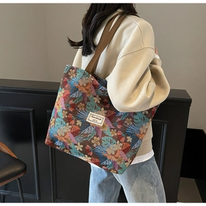 Detail of colorful floral jacquard pattern and branded fabric label on a large tote bag
