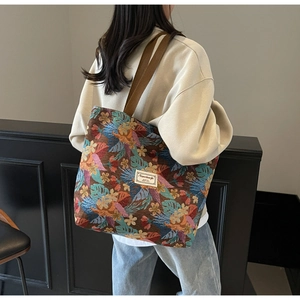 Detail of large ethnic tote bag featuring colorful tropical jacquard and wide brown straps