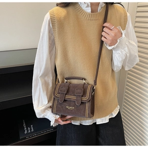 Detailansicht der dunkelbraunen Retro-Satteltasche mit Goldnieten und Markenschriftzug