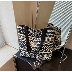 Detailed close-up of a large canvas tote bag with black and white geometric print patterns