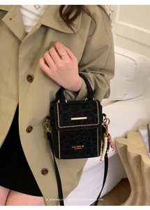 Close-up of leopard print crossbody bag with gold studs and beaded tassel accessory