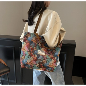 Detail of vintage floral jacquard canvas tote bag with wide brown shoulder straps