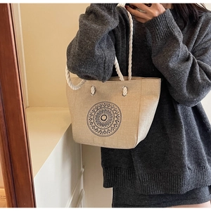 Detail of linen tote bag with mandala print and thick cotton rope handles shown on model