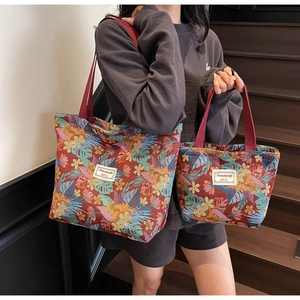 Detail of red jacquard tote bags with tropical leaf pattern and woven straps