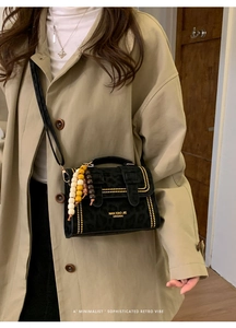 Detail of leopard print suede crossbody bag with gold rivets and colorful wooden beads