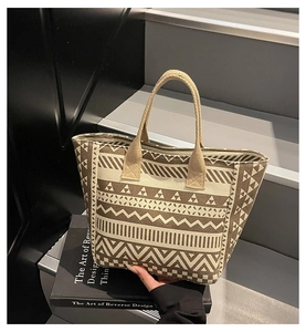 Detail of canvas tote bag showing ethnic geometric patterns on grey stairs