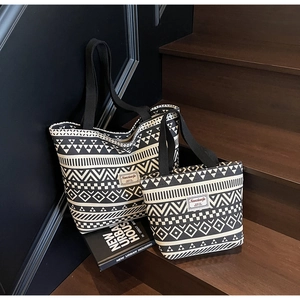 Close-up of geometric pattern canvas tote bags in small and large sizes on wooden stairs
