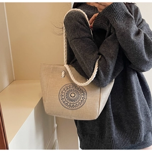Detailed view of beige linen tote bag with black mandala print and white cotton rope handles