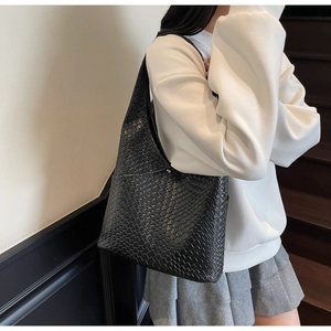 Detailed view of the black woven texture and metal buckle on this large tote bag