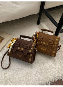 Detail of leopard print crossbody bags with metal studs and decorative wooden beads
