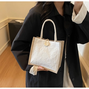 Detail of square lunch bag with white butterfly jacquard fabric and rope handle