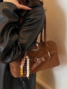 Vintage brown suede handbag with decorative beaded charm and front brand logo print
