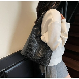 Classic black woven leather tote bag shown on model for a stylish lifestyle look