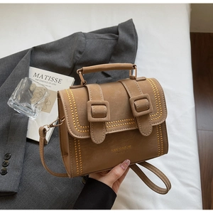 Details der khakifarbenen Vintage-Umhängetasche mit goldenen Nieten und Markenlogo