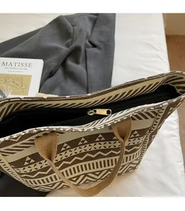 Close-up of smooth gold zipper and tribal pattern canvas on a large tote bag