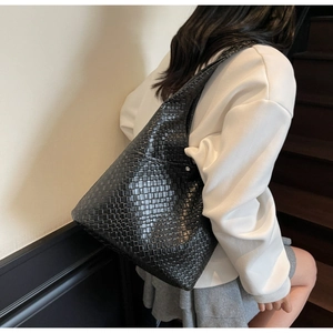 Detail view of black woven hobo bag with a refined textured pattern for women