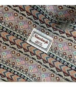 Close-up of geometric jacquard fabric with a white branded label on a tote bag