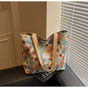 Detail of bohemian tote bag featuring colorful leaf jacquard pattern and sturdy web handles